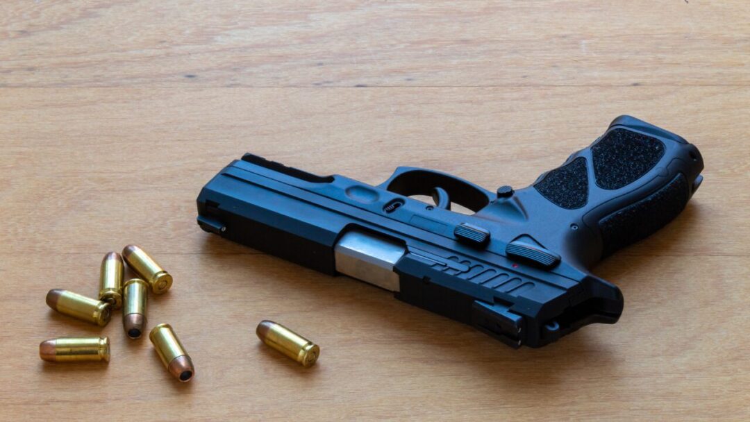 40 caliber pistol surrounded by ammunition on wooden surface.